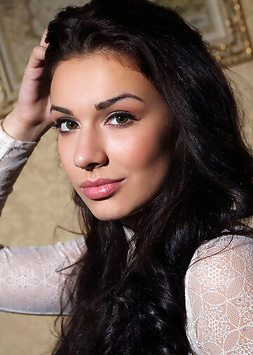 Naked girl with black hair and alluring eyes broadcasts outie muff